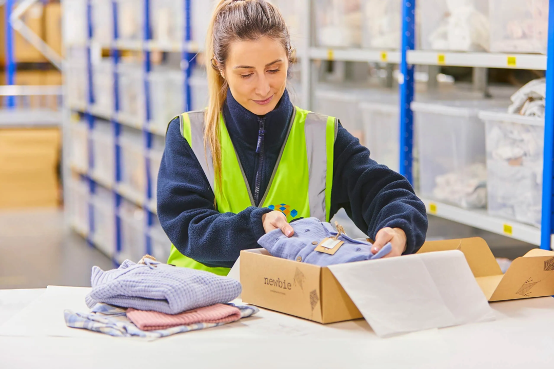 Lady in warehouse marking up pallet for distrubution