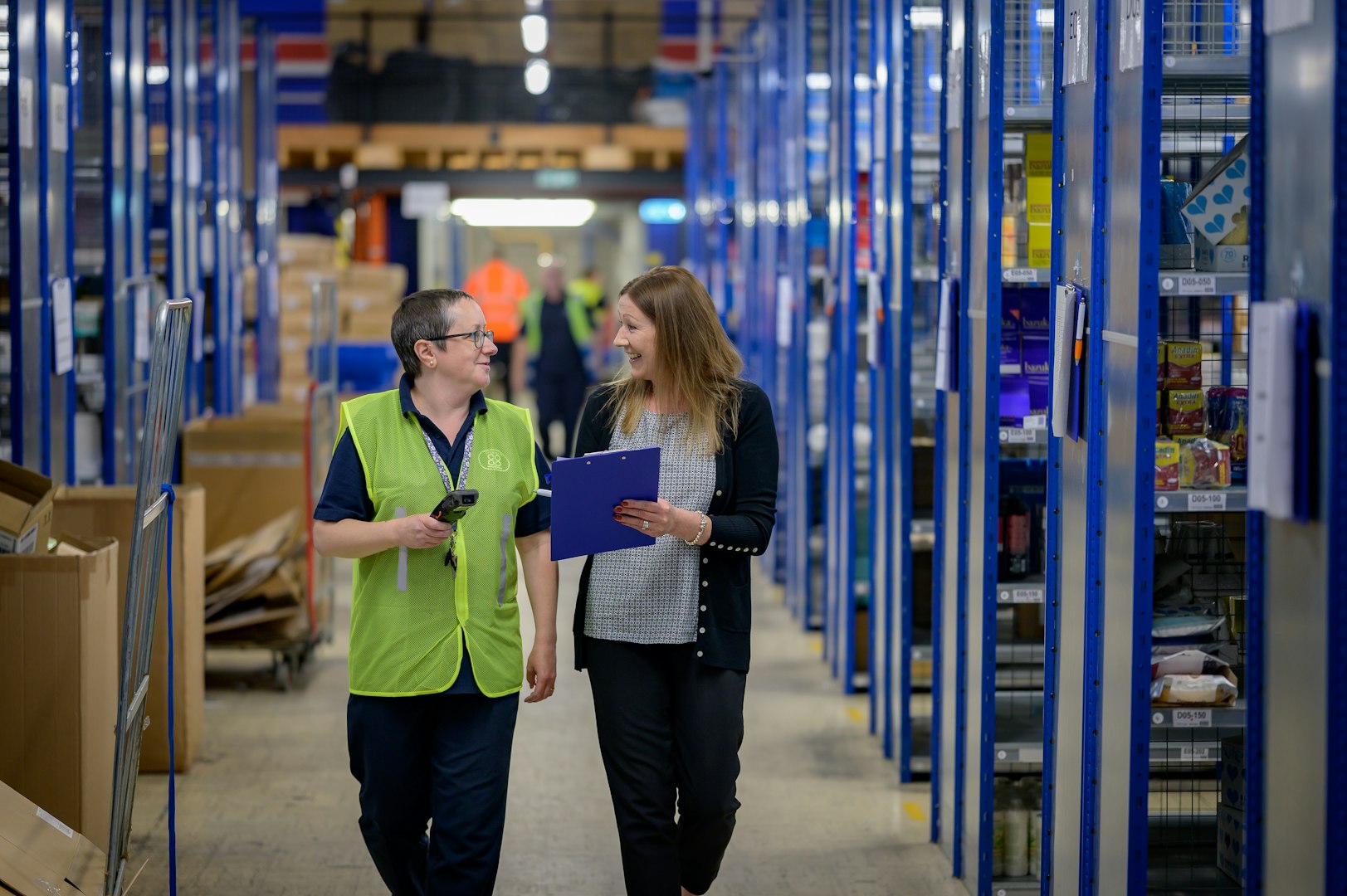 Two ladies walking through warehouse racking